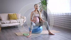 Wellbeing and prenatal fitness lady jumps sitting on ball Spbd