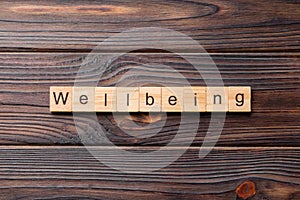 Wellbeing word written on wood block. Wellbeing text on cement table for your desing, concept