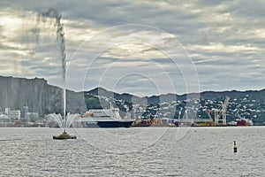 WELLINGTON, NEW ZEALAND - May 28, 2019: Bluebridge ferry at Lambton Harbor with Carter Fountain