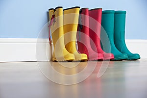 Wellingtons lines up against wall