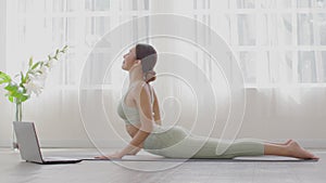 Wellness Attractive Asian woman practice yoga Cobra pose online course at home to meditation comfortable and relax,Yoga online