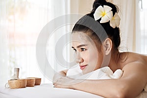 Wellness, beauty and relaxation concept; young Asian woman lying at spa bed