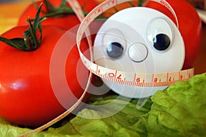 Wellness centimeter with eyes look on tomato and salad