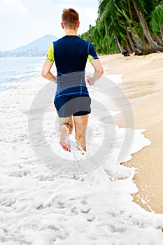 Wellness. Fit Athletic Man Running On Beach,Jogging During Workout.