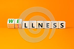 Wellness or illness symbol. Concept words Wellness and Illness on wooden cubes. Beautiful orange table orange background. Medicak