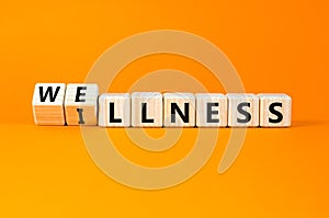 Wellness or illness symbol. Concept words Wellness and Illness on wooden cubes. Beautiful orange table orange background. Medicak