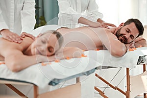 Wellness, massage and relax with a couple in a spa for romance, rest or relaxation on a bed together. Luxury, beauty and