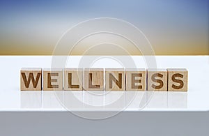 `Wellness` message sign on wooden blocks sitting on a white table