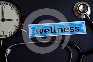 Wellness on the print paper with Healthcare Concept Inspiration. alarm clock, Black stethoscope.