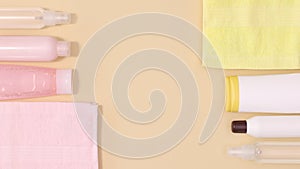 Wellness spa beauty products with towels ordering on left and right side on beige background with copy space. Stop motion flat lay