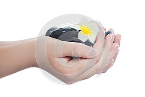 Wellness spa, massage and manicure concept. Black massage stones in woman hands with manicured nails isolated on white background