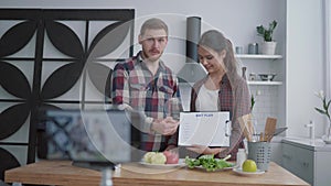 Wellness videoblog, young couple of bloggers broadcast live on healthy nutrition while preparing useful meals from