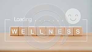 Wellness, wellbeing, relaxation mental health concept. wellness word on wooden cube block with loading and smiling face