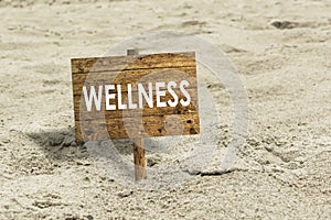 Wellness wooden sign on a beach.