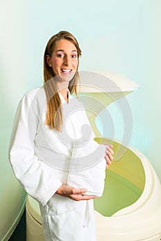 Wellness - young woman floating in Spa in Tank