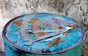 Wenches above a rusty light-blue barrel