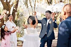 Were all celebrating love and happiness today. a happy newlywed young couple getting showered with confetti outdoors on