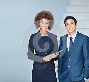 Were eager to grab hold of many more successes. Portrait of two corporate businesspeople standing together in an office.