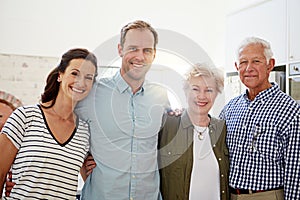 Were a family that stands together. Portrait of a happy married couple posing with their elderly parents at home.