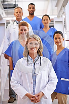 Were here to take care of you. Portrait of a diverse team of medical professionals standing on a staircase in a hospital