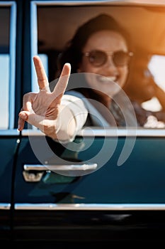 Were hitting the road, peace out. Cropped portrait of an attractive woman giving you a peace sign while enjoying a