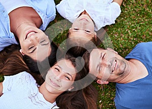 Were just a bunch of peas in a pod. Portrait of a cheerful family lying on the ground together outside in a park during