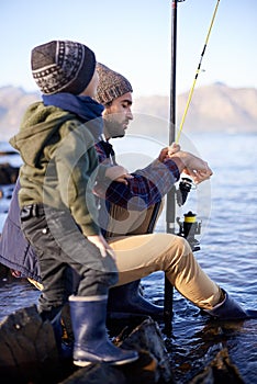 Were almost ready. a father and son fishing by the sea.