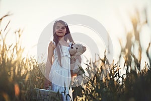 Were ready to leave the farm. Portrait of a cute little girl playing with her teddybear in a cornfield.