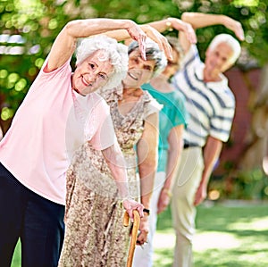 Were seniors and up for anything. a group of smiling seniors exercising outside.