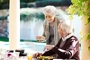 Were starting off our morning on a healthy note. an affectionate senior couple enjoying a meal together outdoors.