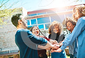 Were stronger together. a diverse group of college friends standing outside with their hands in a huddle.