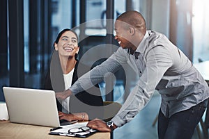 Were such a dynamic team. two businesspeople working together on a laptop in an office.