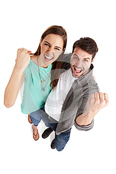 Were a winning combination. High-angle shot of a happy young couple in studio raising their fists in victory.