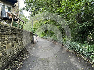 Wesley Place, with a cyclist in the distance in, Silsden, Yorkshire, UK