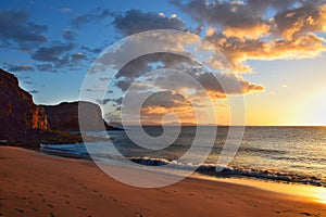 The west coast of Lanzarote at a beautiful sunset. A sandy beach and a blue sky with some clouds. Canary Islands, Spain