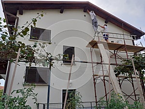 West facade of house undergoing renovation with painting in white facade colour