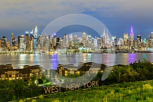 West New York City midtown Manhattan skyline view from Boulevard East Old Glory Park over Hudson River at dusk.