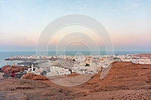 West part of Sur town with Al-Ayjah Castle, mosque in golden hour, Oman