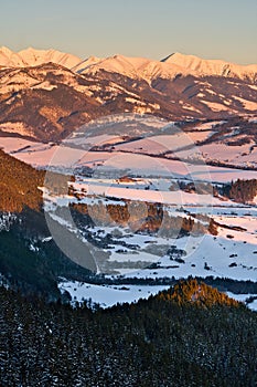 West Tatras from Janosikov stol rock over Liptovska Anna village in Chocske vrchy mountains during winter