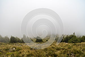 Western carpathian mountain tops in autumn covered in mist or cl