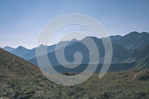 Western carpathian mountain tops in autumn covered in mist or clouds with blue cast and multidimensional lines - vintage old film