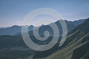 Western carpathian mountain tops in autumn covered in mist or clouds with blue cast and multidimensional lines - vintage old film