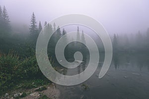 Misty morning view in wet mountain area in slovakian tatra. mountain lake panorama - vintage film look