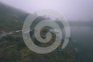 Misty morning view in wet mountain area in slovakian tatra. mountain lake panorama - vintage film look