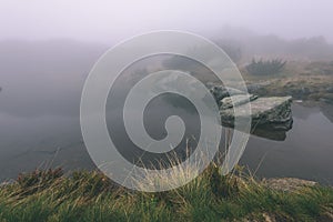 Misty morning view in wet mountain area in slovakian tatra. mountain lake panorama - vintage film look