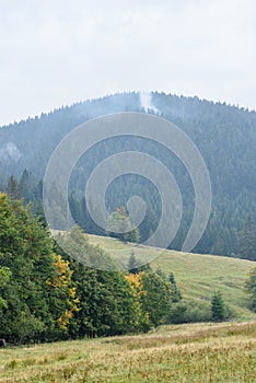 Vrcholy hôr na jeseň pokryté hmlou alebo mrakmi