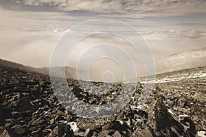 Mountain tops in autumn covered in mist or clouds - soft vintag