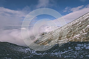 Mountain tops in autumn covered in mist or clouds- vintage effe