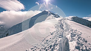 Horské vrcholy v zimě pokryté sněhem s jasným sluncem a modrou