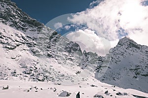 Mountain tops in winter covered in snow with bright sun and blue